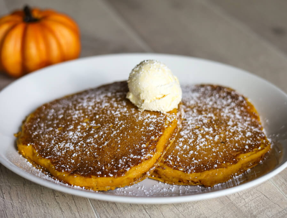 Two house-made pumpkin flapjacks, honey whipped butter, powdered sugar, pure maple syrup